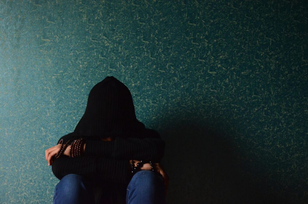 pexels-photo-278303-278303 A person sits alone in a hoodie, conveying a sense of solitude and introspection.