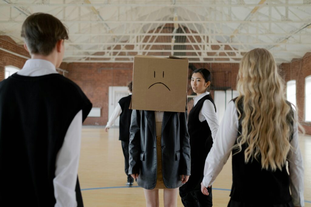 pexels-photo-7407376-7407376 Students in a school gym highlighting themes of bullying and peer pressure.